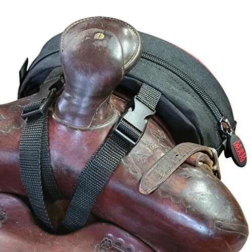 Leather horse saddle with attached black bag.