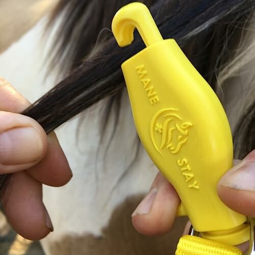 Hands using Mane Stay tool on horse's mane.